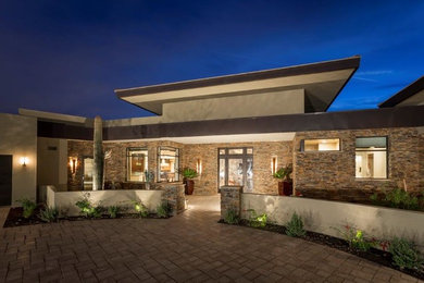 Example of a large beige one-story mixed siding flat roof design in Phoenix