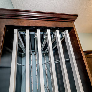 シカゴの中サイズのトラディショナルスタイルのおしゃれな家事室 (エプロンフロントシンク、落し込みパネル扉のキャビネット、茶色いキャビネット、緑の壁、セラミックタイルの床、目隠し付き洗濯機・乾燥機、茶色い床、グレーのキッチンカウンター) の写真