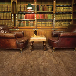 This is an example of a large traditional home office in Other with a library and cork floors.