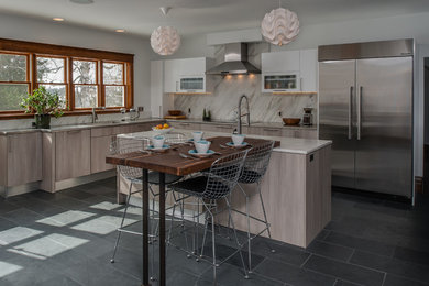 Large contemporary l-shaped eat-in kitchen in Other with an undermount sink, flat-panel cabinets, light wood cabinets, marble benchtops, multi-coloured splashback, stone slab splashback, stainless steel appliances, slate floors and with island.