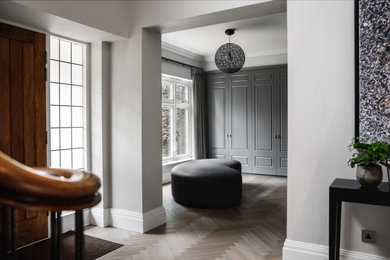 Classic entrance in Cheshire with grey walls, medium hardwood flooring, a double front door, a medium wood front door, grey floors and a feature wall.