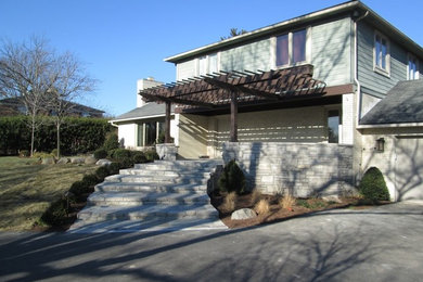 Inspiration for a timeless stone front porch remodel in Other with a pergola