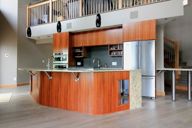 Inspiration for a large contemporary single-wall medium tone wood floor and gray floor open concept kitchen remodel in Other with an undermount sink, flat-panel cabinets, dark wood cabinets, granite countertops, gray backsplash, cement tile backsplash, stainless steel appliances and an island