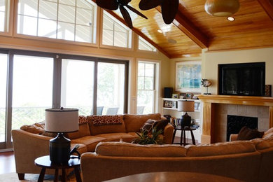 Example of a mid-sized arts and crafts open concept concrete floor and brown floor family room design in Atlanta with beige walls, a standard fireplace, a tile fireplace and a wall-mounted tv