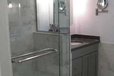 Small elegant master gray tile and porcelain tile porcelain tile corner shower photo in New York with flat-panel cabinets and gray cabinets