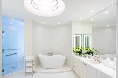 Design ideas for a large contemporary master bathroom in Tampa with shaker cabinets, white cabinets, a freestanding tub, white tile, white walls, travertine floors, an undermount sink and quartzite benchtops.