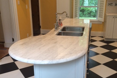 Eat-in kitchen - mid-sized transitional single-wall linoleum floor eat-in kitchen idea in Cincinnati with a double-bowl sink, recessed-panel cabinets, white cabinets, marble countertops, white backsplash, subway tile backsplash, stainless steel appliances and an island