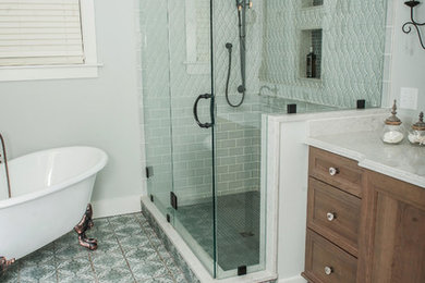 Design ideas for a large contemporary master bathroom in Providence with flat-panel cabinets, medium wood cabinets, a freestanding tub, a corner shower, a two-piece toilet, white tile, ceramic tile, white walls, ceramic floors, a drop-in sink, marble benchtops, multi-coloured floor, a hinged shower door and white benchtops.