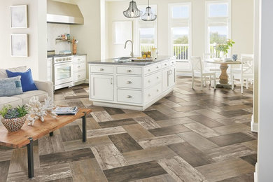 Mid-sized beach style single-wall porcelain tile open concept kitchen photo in Chicago with an undermount sink, shaker cabinets, white cabinets, stainless steel countertops, white backsplash, ceramic backsplash, white appliances and an island