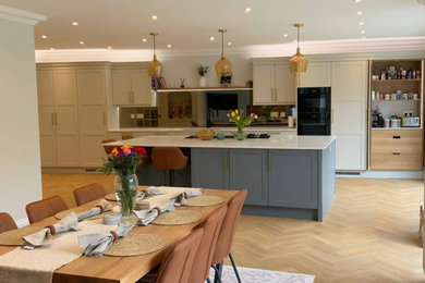 Design ideas for a large classic kitchen in Buckinghamshire with shaker cabinets, quartz worktops, metallic splashback, mirror splashback, integrated appliances, an island and white worktops.