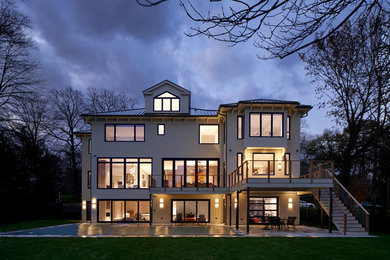 Large transitional white two-story stucco house exterior idea in New York with a hip roof and a metal roof