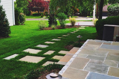 This is an example of a mid-sized modern backyard stone landscaping in New York.