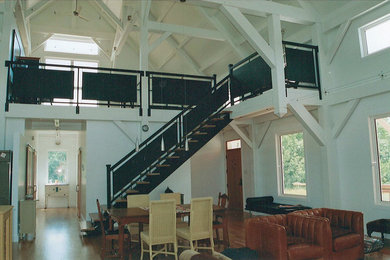 Example of a mid-sized trendy brown floor and vaulted ceiling kitchen/dining room combo design in Other with white walls