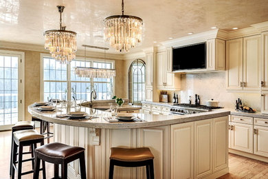 Large elegant l-shaped light wood floor and beige floor open concept kitchen photo in Portland Maine with an undermount sink, raised-panel cabinets, beige cabinets, granite countertops, beige backsplash, stainless steel appliances and an island