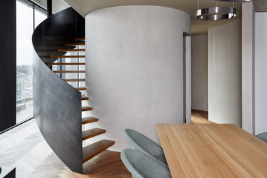 Gewendelte, Große Moderne Treppe mit gebeizten Holz-Treppenstufen und Stahlgeländer in Sonstige