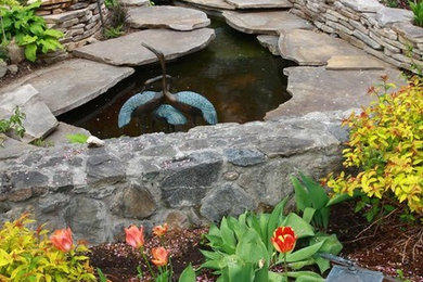 Inspiration for a mid-sized traditional backyard garden in Salt Lake City with a water feature and natural stone pavers.