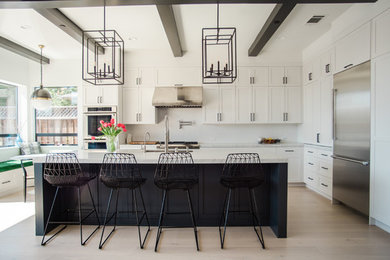 Open concept kitchen - large transitional l-shaped light wood floor open concept kitchen idea in San Francisco with a single-bowl sink, shaker cabinets, white cabinets, marble countertops, white backsplash, subway tile backsplash, stainless steel appliances and an island
