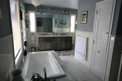 Example of a large master white tile marble floor, white floor and double-sink drop-in bathtub design in New York with distressed cabinets, gray walls, an undermount sink and marble countertops