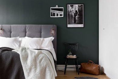 Photo of a mid-sized scandinavian master bedroom in Gothenburg with green walls, light hardwood floors and brown floor.