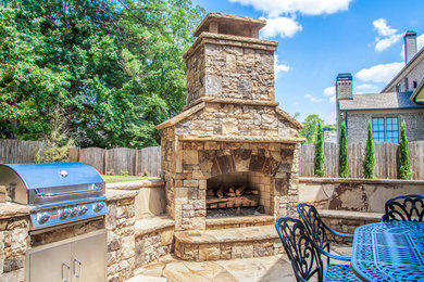 Example of a mid-sized classic backyard stone patio design in Atlanta with a fire pit and no cover