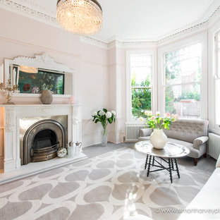 Inredning av ett modernt stort separat vardagsrum, med rosa väggar, en standard öppen spis och en spiselkrans i sten