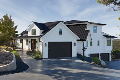 Large cottage white three-story stucco house exterior idea in Austin with a metal roof and a black roof