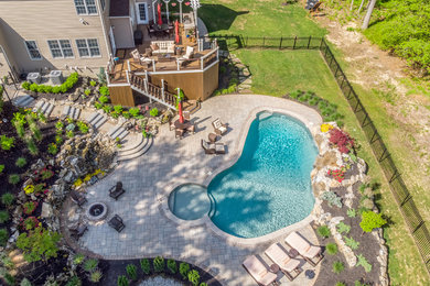 Inspiration for a huge timeless backyard natural pool remodel in New York