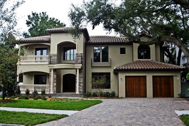 Example of a large classic beige two-story stucco exterior home design in Tampa with a tile roof