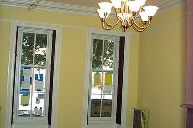 Living room - large 1960s formal and enclosed dark wood floor living room idea in Baltimore with yellow walls, a standard fireplace and a stone fireplace