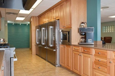 Imagen de cocina clásica grande con armarios con paneles con relieve, puertas de armario de madera oscura, electrodomésticos de acero inoxidable y suelo beige