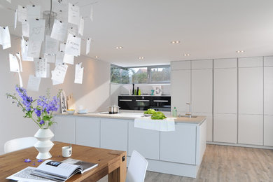 Offene, Geräumige Moderne grifflose Küche mit integriertem Waschbecken, flächenbündigen Schrankfronten, weißen Schränken, Betonarbeitsplatte, schwarzen Elektrogeräten, hellem Holzboden, Halbinsel und Küchenrückwand in Weiß in Berlin