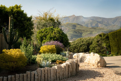 Design ideas for a large contemporary desert and full sun gravel and wood fence driveway in Santa Barbara.