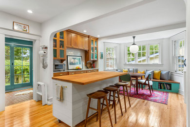 Example of a large transitional light wood floor and brown floor kitchen design in Philadelphia with a farmhouse sink, shaker cabinets, marble countertops, multicolored backsplash, subway tile backsplash, stainless steel appliances, an island and multicolored countertops