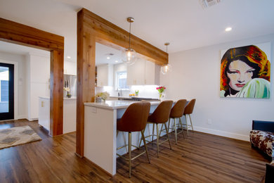 Small trendy u-shaped brown floor kitchen photo in Houston with a single-bowl sink, flat-panel cabinets, white cabinets, quartz countertops, white backsplash, ceramic backsplash, stainless steel appliances, an island and white countertops