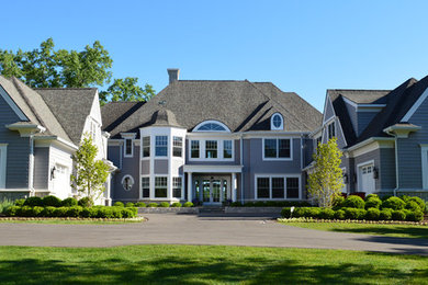 Large transitional three-storey grey house exterior in Detroit with wood siding, a hip roof and a shingle roof.
