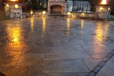 Large elegant backyard concrete paver patio photo in Boston with a fire pit and no cover