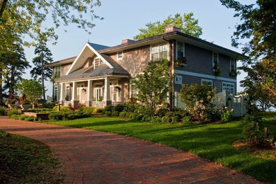 Large traditional beige two-story wood exterior home idea in Grand Rapids with a shingle roof