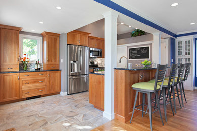 Elegant galley kitchen photo in Boston with shaker cabinets, medium tone wood cabinets, multicolored backsplash, matchstick tile backsplash and stainless steel appliances