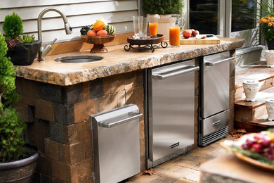 Example of a large mountain style backyard brick patio kitchen design in Other with a pergola