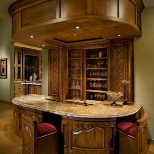 オレンジカウンティのヴィクトリアン調のおしゃれな着席型バー (大理石カウンター、コンクリートの床、茶色い床、濃色木目調キャビネット) の写真