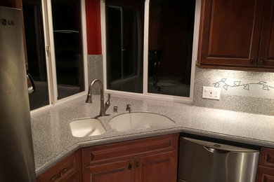 Inspiration for a kitchen remodel in Los Angeles with brown cabinets, solid surface countertops and gray backsplash