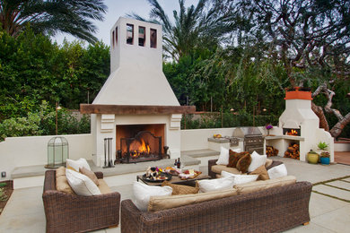 This is an example of a large traditional backyard patio in Orange County with an outdoor kitchen and concrete pavers.