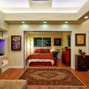 Idee per una grande camera matrimoniale etnica con pareti gialle, pavimento in legno massello medio, nessun camino e pavimento marrone