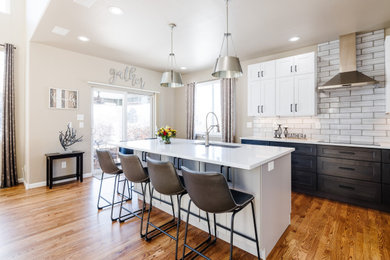 Example of a mid-sized trendy galley dark wood floor and brown floor open concept kitchen design in Denver with a single-bowl sink, shaker cabinets, quartz countertops, gray backsplash, subway tile backsplash, stainless steel appliances, an island and white countertops