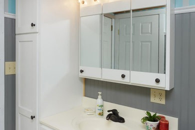 Mid-sized elegant 3/4 ceramic tile and gray floor bathroom photo in Other with shaker cabinets, white cabinets, gray walls, an integrated sink, solid surface countertops and white countertops