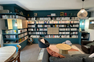 Réalisation d'un salon minimaliste de taille moyenne et ouvert avec une bibliothèque ou un coin lecture, un mur blanc, un sol en carrelage de céramique, aucune cheminée, un téléviseur dissimulé et un sol beige.