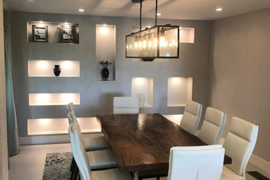 Inspiration for a large porcelain tile and gray floor enclosed dining room remodel in Tampa with gray walls