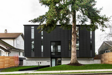 Ejemplo de fachada de casa negra y gris vintage grande de tres plantas con revestimiento de metal, tejado a dos aguas y tejado de teja de madera