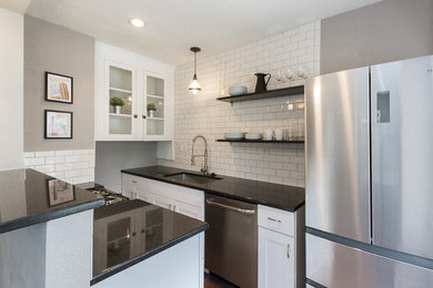 Kitchen - small country galley medium tone wood floor and brown floor kitchen idea in Kansas City with an undermount sink, shaker cabinets, white cabinets, granite countertops, white backsplash, subway tile backsplash, stainless steel appliances and a peninsula
