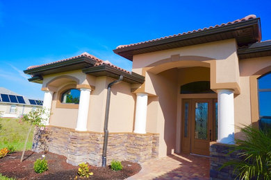 Example of a mid-sized tuscan travertine floor open concept kitchen design in Tampa with raised-panel cabinets, brown cabinets, quartz countertops, multicolored backsplash, stainless steel appliances and an island